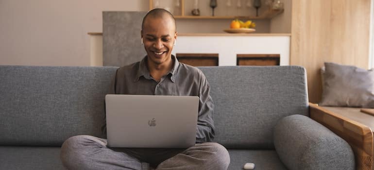 A person sitting on a couch with a laptop on their lap