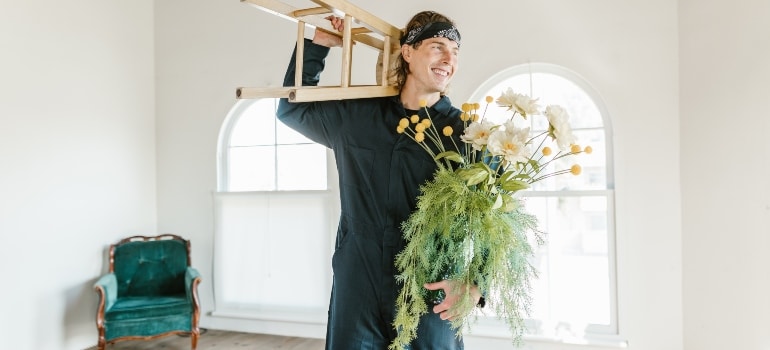 mover holding a stool and flowers
