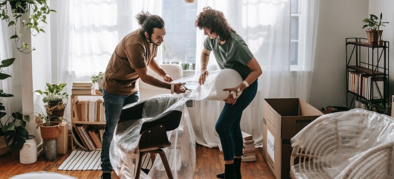 Couple packing furniture for moving from state to state